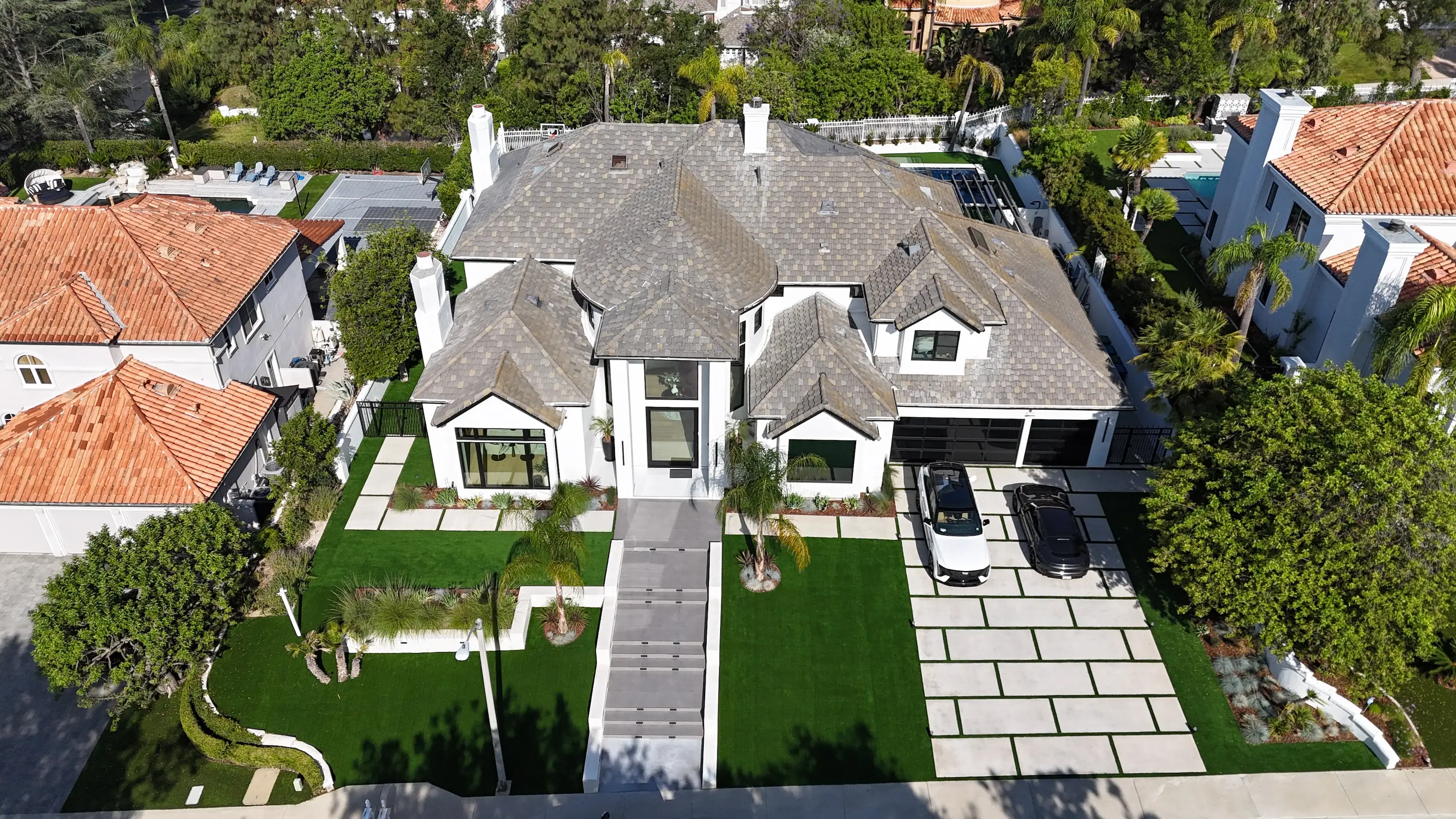 Aerial view of a two-story home with a new gray roof by White Palm Roofing